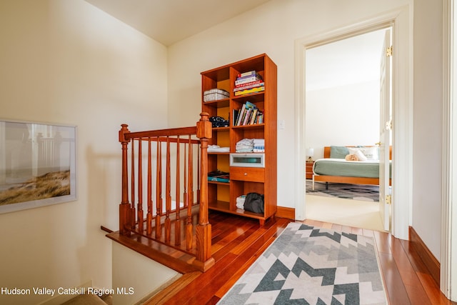 hallway with hardwood / wood-style flooring