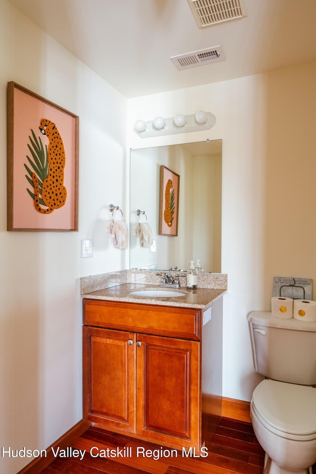 bathroom with vanity, hardwood / wood-style floors, and toilet