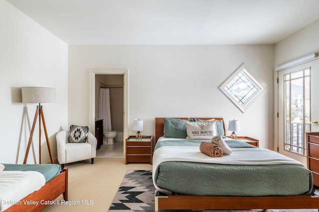 bedroom with light carpet, access to exterior, and ensuite bath