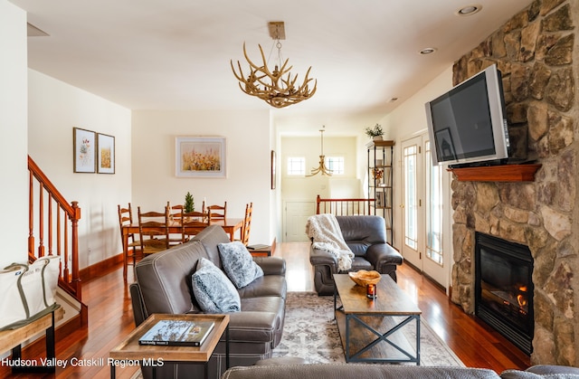 living room featuring dark wood-type flooring, a fireplace, and a chandelier