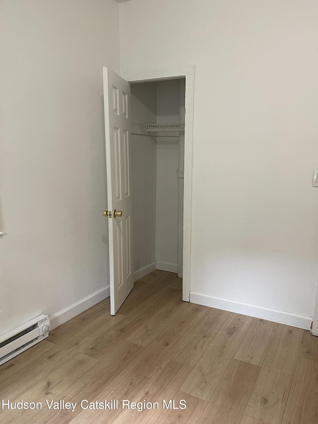 6 Church St, Ellenville, NY 12428 - unfurnished bedroom featuring light wood-type flooring, baseboard heating, and a closet