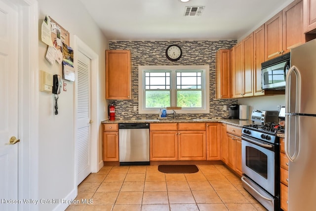 6 Trailside Dr Unit A8, Hunter, NY 12442 - kitchen featuring appliances with stainless steel finishes, stone countertops, backsplash, and light tile patterned flooring