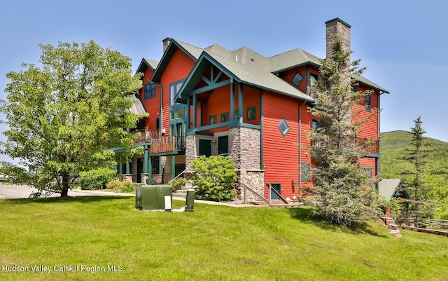 6 Trailside Dr Unit A8, Hunter, NY 12442 - back of house featuring a chimney, stone siding, and a lawn