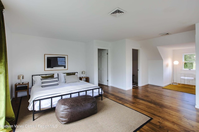 bedroom with dark hardwood / wood-style flooring and connected bathroom