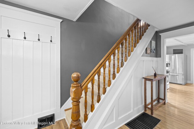 staircase featuring wood finished floors and a decorative wall