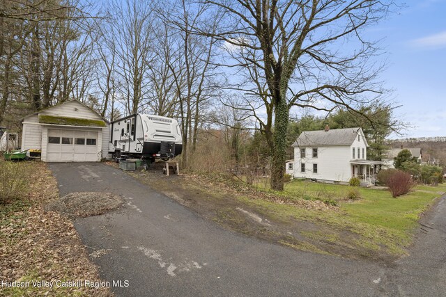 view of home's exterior with an outdoor structure and a detached garage
