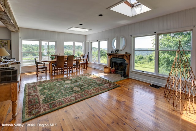 3721 Ridge Rd, Hamden, NY 13782 - dining room featuring a skylight, hardwood / wood-style flooring, healthy amount of natural light, and a fireplace with flush hearth