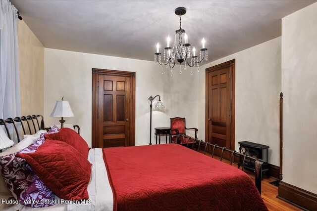 1 Waddell Ave, Fort Plain, NY 13339 - bedroom featuring a chandelier, wood finished floors, and baseboards