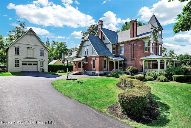 1 Waddell Ave, Fort Plain, NY 13339 - victorian home with a garage, driveway, a chimney, brick siding, and a front lawn