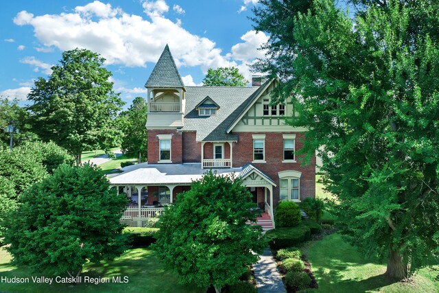 1 Waddell Ave, Fort Plain, NY 13339 - victorian-style house featuring a balcony, brick siding, covered porch, and a front yard