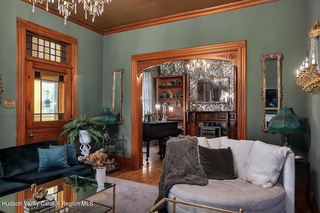 1 Waddell Ave, Fort Plain, NY 13339 - living room with crown molding, wood finished floors, a fireplace, a chandelier, and baseboards