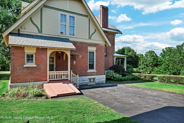 1 Waddell Ave, Fort Plain, NY 13339 - rear view of house featuring a chimney, a shingled roof, brick siding, and a yard