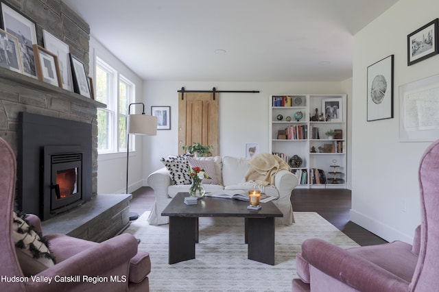 living room featuring a barn door and wood-type flooring