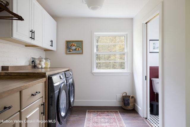 laundry area featuring separate washer and dryer, cabinets, and dark hardwood / wood-style floors