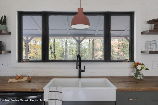 kitchen featuring butcher block countertops, dishwasher, a healthy amount of sunlight, and sink