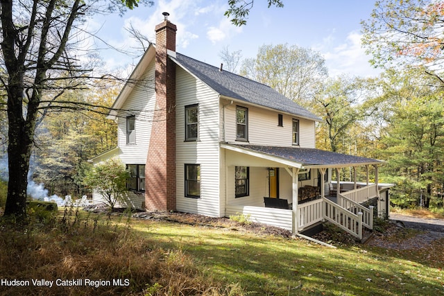 farmhouse-style home with covered porch and a front yard