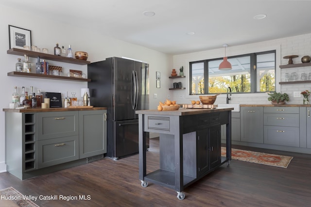 kitchen featuring stainless steel fridge, dark hardwood / wood-style floors, and gray cabinetry