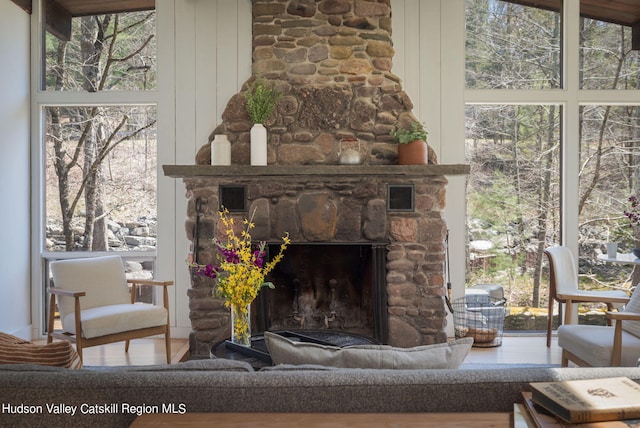 living room featuring hardwood / wood-style flooring, wood walls, and a fireplace