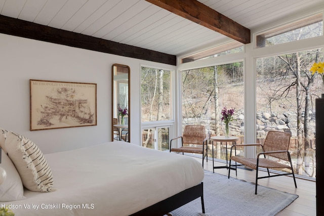 bedroom featuring lofted ceiling with beams, light hardwood / wood-style floors, and wood ceiling