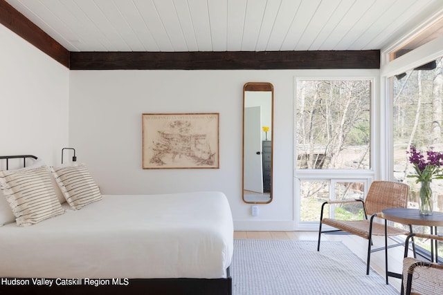 bedroom featuring beam ceiling, wooden ceiling, and multiple windows