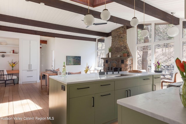 kitchen with green cabinets, hardwood / wood-style floors, a kitchen island, and a healthy amount of sunlight