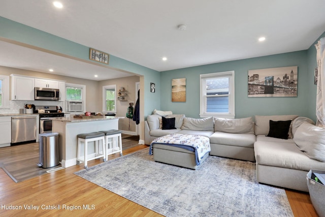 living area featuring cooling unit, recessed lighting, and light wood-type flooring