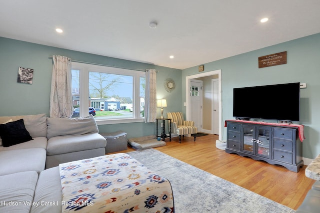 living room with light wood finished floors, recessed lighting, and baseboards