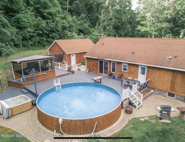 view of swimming pool with a wooden deck, a gazebo, and a hot tub