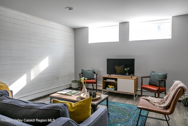 living room with wood-type flooring, a healthy amount of sunlight, and wooden walls