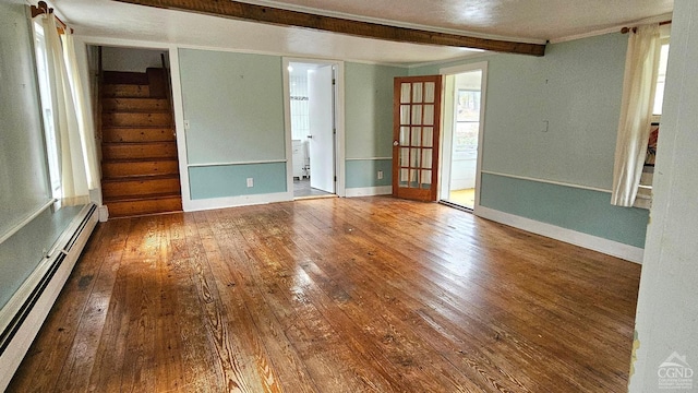 unfurnished room with a baseboard radiator, wood-type flooring, crown molding, baseboards, and stairway