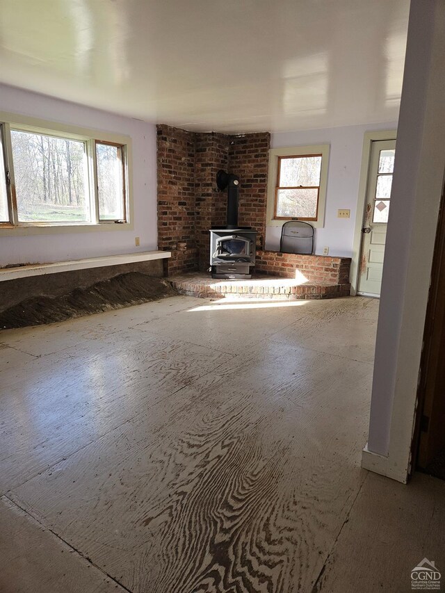 unfurnished living room with a wood stove