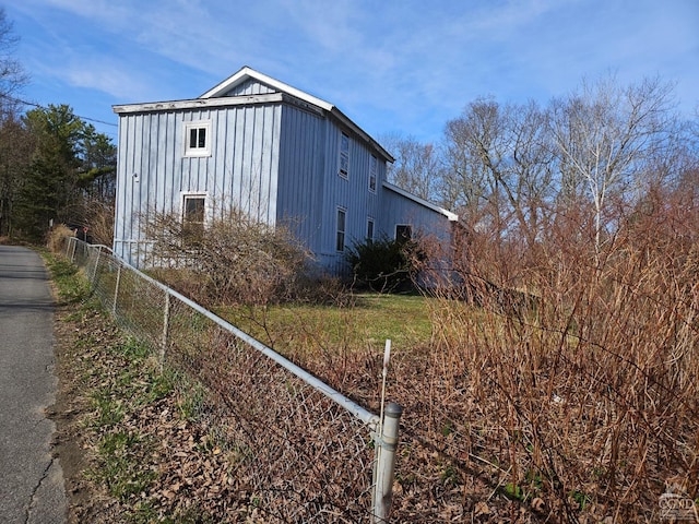 view of home's exterior featuring board and batten siding and fence