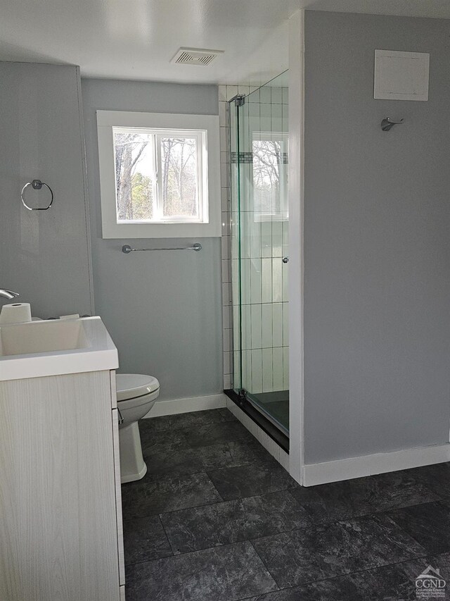 full bath with baseboards, a stall shower, toilet, and vanity