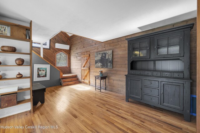 living room with wooden walls and light wood-style flooring