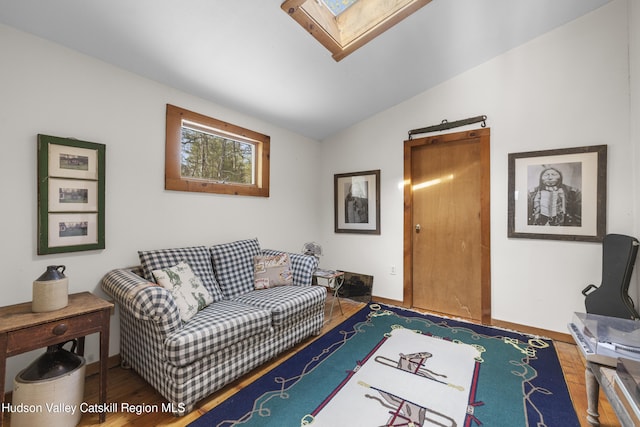 living room with lofted ceiling with skylight and wood finished floors