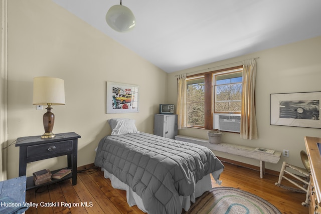 bedroom featuring baseboards, cooling unit, vaulted ceiling, and hardwood / wood-style flooring