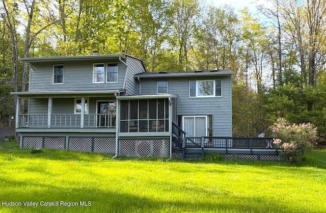 back of property with a lawn and a deck