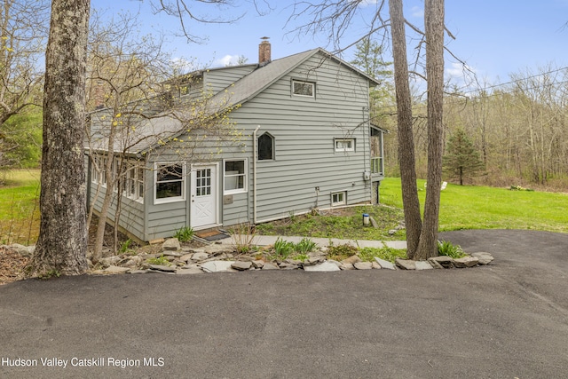 exterior space with a yard and a chimney