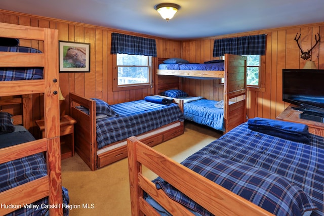 bedroom with light carpet and wood walls