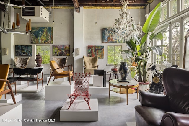 827 Union St, Hudson, NY 12534 - living area featuring concrete flooring, a chandelier, a high ceiling, and a heating unit