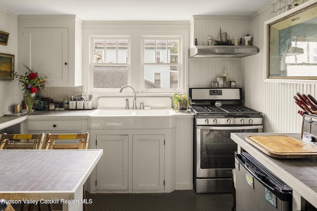 827 Union St, Hudson, NY 12534 - kitchen with stainless steel gas stove, tile countertops, exhaust hood, and dishwashing machine