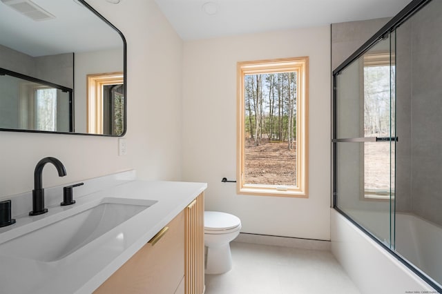 full bathroom with vanity, toilet, and combined bath / shower with glass door