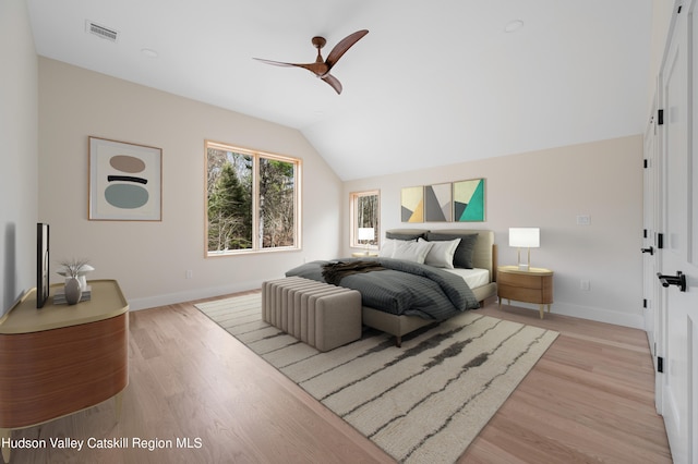 bedroom featuring light hardwood / wood-style flooring, vaulted ceiling, and ceiling fan