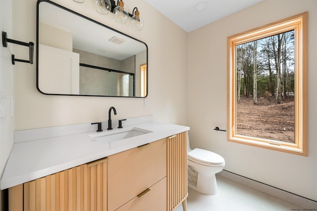 bathroom featuring vanity, toilet, and walk in shower