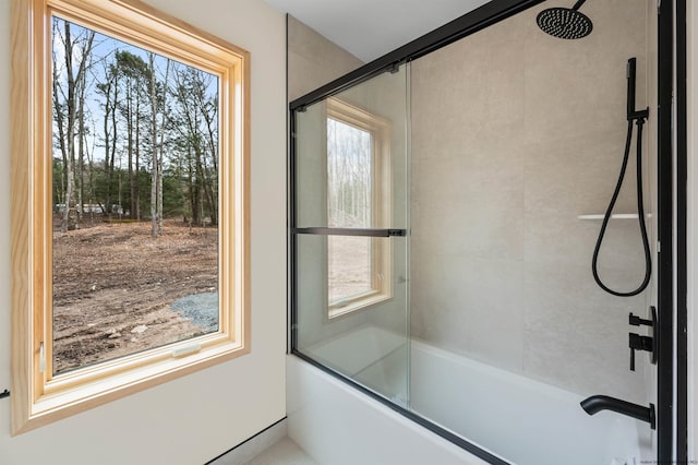 bathroom featuring combined bath / shower with glass door and plenty of natural light