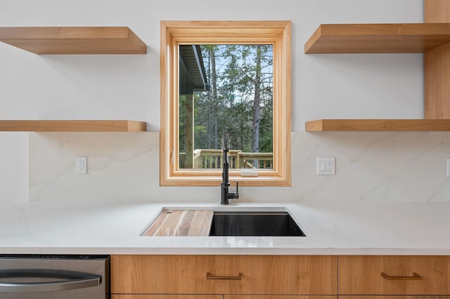 kitchen featuring stainless steel dishwasher, backsplash, and sink