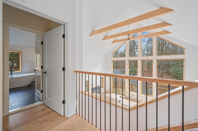 hall with vaulted ceiling with beams and light wood-type flooring