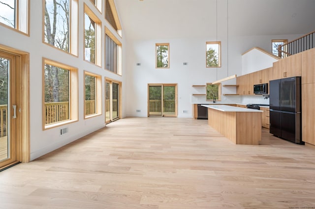 kitchen featuring a center island, plenty of natural light, and black appliances