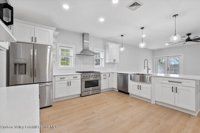 26 Debbie Dr, Athens, NY 12015 - kitchen with wall chimney range hood, recessed lighting, a peninsula, light countertops, and appliances with stainless steel finishes