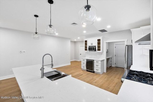 26 Debbie Dr, Athens, NY 12015 - kitchen with visible vents, wall chimney exhaust hood, stainless steel appliances, beverage cooler, and a sink